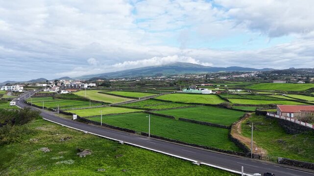 Drone panorama of vibrant agricultural fields and countryside landscape with mountain backdrop on Terceira Island in the Azores Portugal