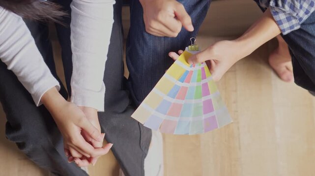 Couple sitting together and choosing interior paint colors from fan deck