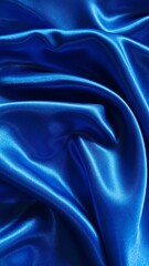 Fototapeta premium Luxurious royal blue satin fabric shimmers with elegant folds, creating a rich and sophisticated abstract texture.