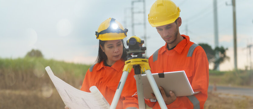 Technicians are using surveying equipment to inspect the integrity of the road construction at the wind turbine farm.