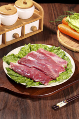 Fototapeta premium Fresh Ningxia Lamb Meat Slices on Lettuce with Vegetables Kitchen Setup