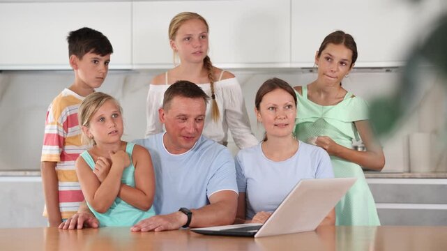 Big tight-knit friendly family getting together at kitchen for making video call