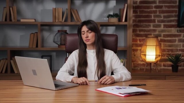 Business woman shows disappointment as she discards papers at desk in office.
