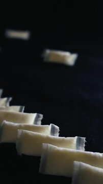 Close up studio shot of smokeless tobacco free nicotine pouches arranged in a row and, showcasing a popular alternative to traditional smoking on a dark background