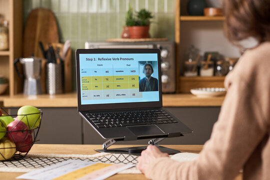 Middle aged Caucasian woman learning language online on laptop at home, studying grammar during video lesson. Useful for e learning, adult education, remote training marketing