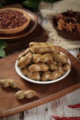 Fototapeta premium Boiled Marinated Peanuts with Salt Water and Spices on Rustic Wooden Table - Traditional Healthy Snack Food