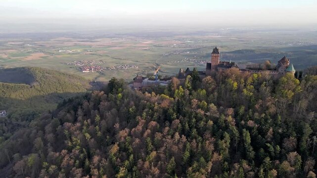 Aerial orbital drone view of medieval castle tower and fortification walls showing sandstone masonry details and defensive architecture. Close inspection of battlements and turrets from circling