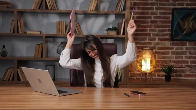 Caucasian business woman celebrates success by dancing with documents.