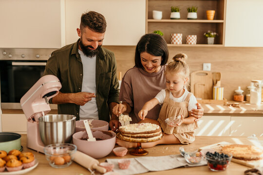 Family baking cake together in kitchen at home