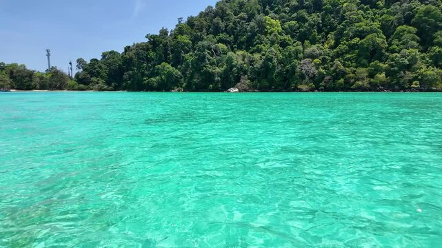 Exotic paradise bay showcasing vibrant translucent water, representing peaceful marine nature exploration, island hopping travel, and serene coastal getaways.