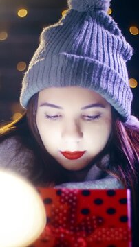 Shining from Christmas gift box over the face of cute young woman smile