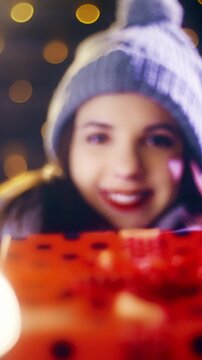 Beautiful girlfriend gives Christmas present gift box to the camera POV