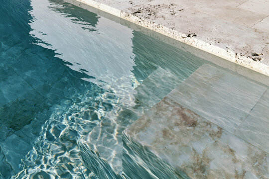 Luxury swimming pool with travertine stone steps and rippling turquoise water in Mediterranean outdoor setting.