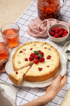 Serving Homemade baked cheesecake with fresh raspberries. Kompot drink. Vertical image.