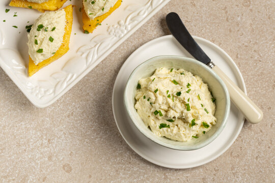 Top view of small bowl  with baccala mantecato cream, whipped, creamed salt cod fish spread, polenta croutons.