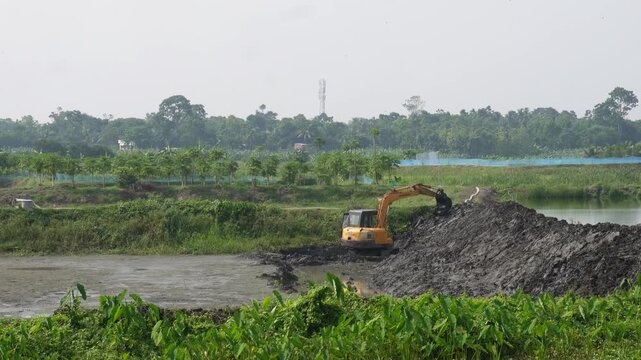 Backhoe loader boldly moving through muddy construction site