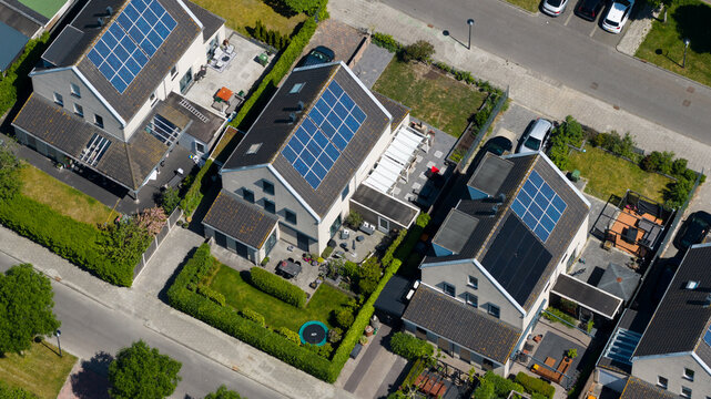 Aerial view of modern houses with solar panels on rooftops and green gardens in Heerhugowaard, North Holland, Netherlands.