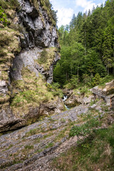 Fototapeta premium Crystal Clear Weissbach Stream Flowing through Rocky Gorge in the Bavarian Alps Germany