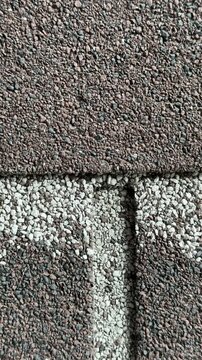 Close-up ondulin roof tiles textured granules macro detail showing layered shingle surface, contractor inspection and installation