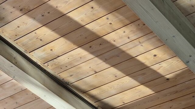 Light reflected on water illuminates a wooden ceiling inside a spa