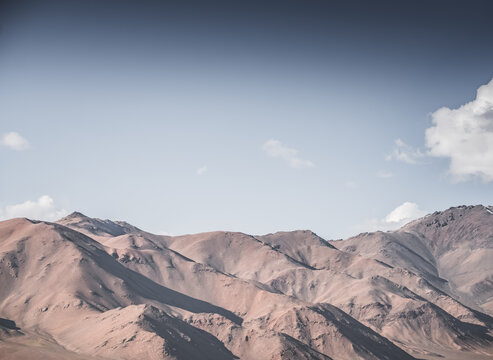 Rocky mountain slopes in the Pamir Mountains in Tajikistan, a minimalist landscape and rocky hills in sunny weather