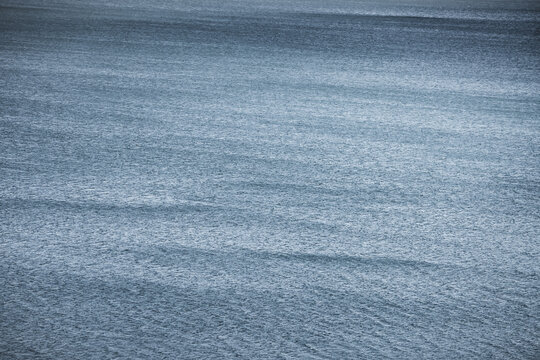 The water surface of the blue mountain lake Yashilkul, the texture of the water and the waves from the wind, for background