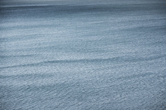 The water surface of the blue mountain lake Yashilkul, the texture of the water and the waves from the wind, for background