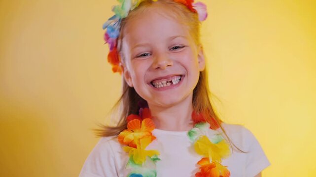 Close-Up Happy Little Girl In Hawaiian Style Smiling With Missing Baby Teeth On Yellow Background