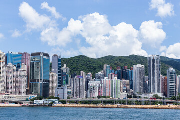 Obraz premium Hong Kong Victoria Harbor Skyline with Modern Architecture and Mountains