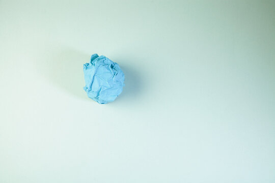 Blue paper ball on a white background. Copy space for text.