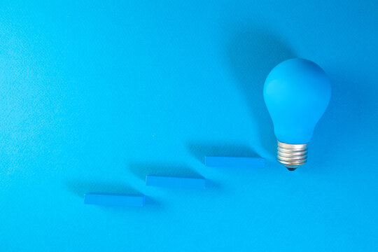Blue light bulb on a blue background. The concept of creativity and innovation.