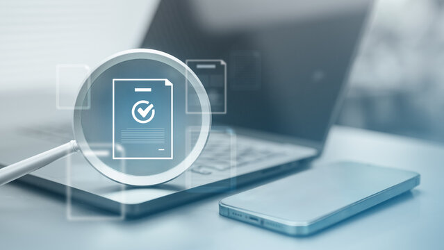 Magnifying glass inspecting digital document and audit file on laptop for verification, compliance, and secure document management.