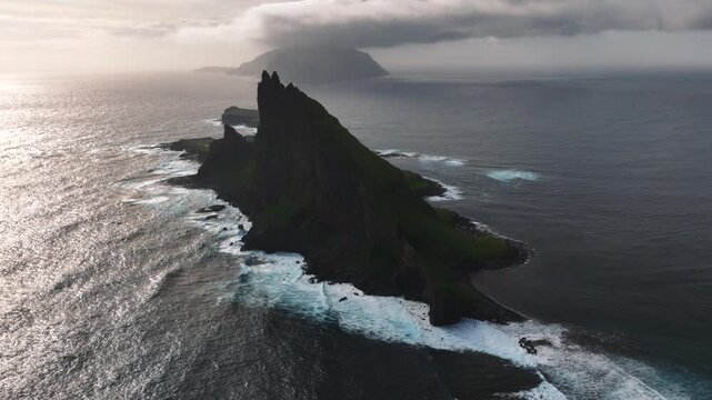 Tindholmur sea stacks rising from the North Atlantic near Sorvagur, Vagar Island, Faroe Islands, Kingdom of Denmark, with dramatic volcanic cliffs and ocean swells, slow aerial parallax orbit