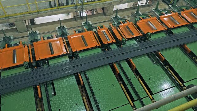 Automated handling system using roller or chain conveyors to move long metal profiles in factory