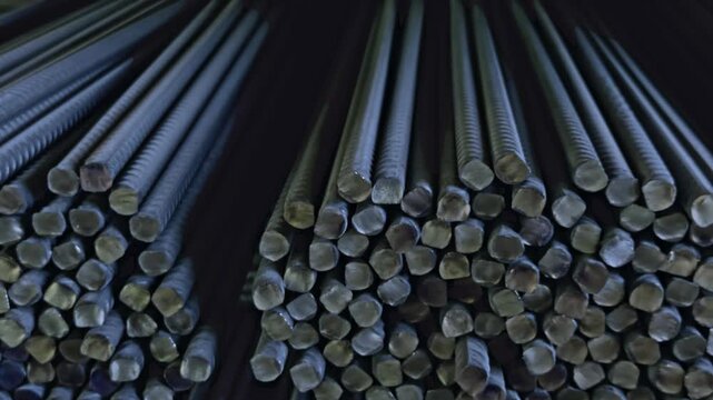 Close-up of stacked corrugated steel rebars ready for transport inside modern steel mill