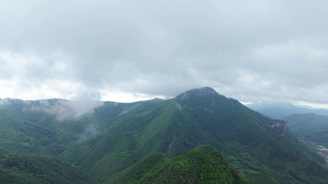 Beautiful drone shot flying above lush green forests and cloudy mountain valleys near Teteven, Bulgaria. Scenic European wilderness landscape ideal for travel, adventure, hiking, and eco tourism conce
