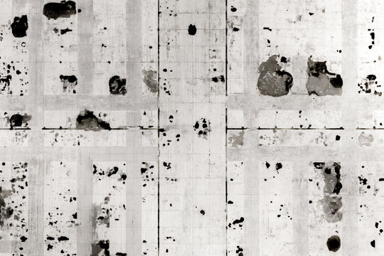 Aerial view of an abstract urban grid pattern with dark spots and textured surfaces in black and white Warsaw, Masovian Voivodeship, Poland.
