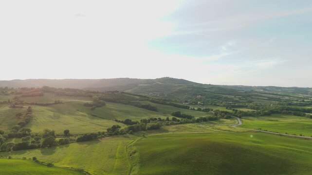 Sunset aerial view of rolling countryside and winding road in Val d&rsquo;Orcia Tuscany