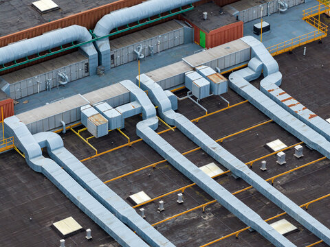 Aerial view of industrial HVAC systems with large metal ventilation ducts and pipes on a flat building rooftop Warsaw, Masovian Voivodeship, Poland.