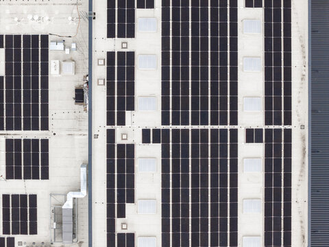 Aerial view of bakery facility with rows of solar panels on the rooftop and industrial ventilation systems Warszawa, Wojewodztwo mazowieckie, Poland.