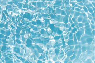 Fototapeta premium Blue water with ripples on the surface. Defocus blurred transparent blue colored clear calm water surface texture with splashes and bubbles. Water waves with shining pattern texture background.