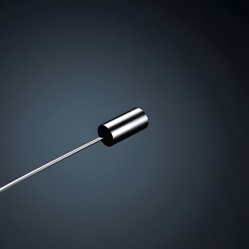 An unpowered laser diode module face-on against a dark blue-grey gradient &mdash; inactive lens facing the camera, cylinder lit by single cold overhead light, wire leads trailing out of frame. 