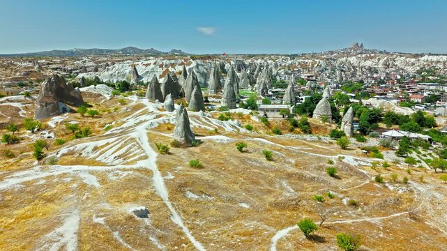 Aerial view of Goreme, Cappadocia, Turkey dry valley. Pathways, rocky hills and distant fairy chimneys fill a wide travel panorama.