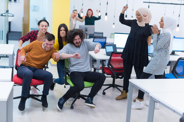 Fototapeta premium Coworkers Having Fun With Office Chair Races