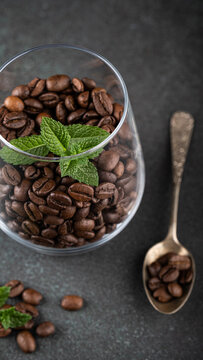 Coffee beans are displayed in a glass with fresh mint leaves, accompanied by a vintage spoon, creating an inviting and aromatic scene, stories templates with copy space