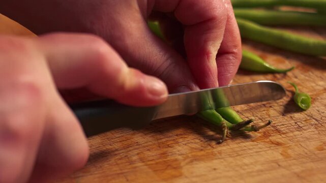 Hands chopping raw green beans