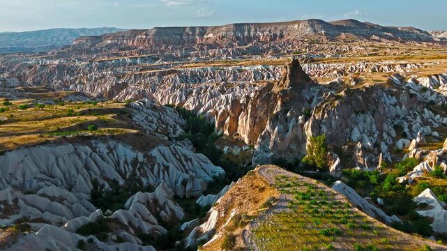 Aerial view of Rose Valley, Cappadocia, Turkey cliffs. Deep canyons, eroded rock walls and warm evening light reveal a dramatic landscape.