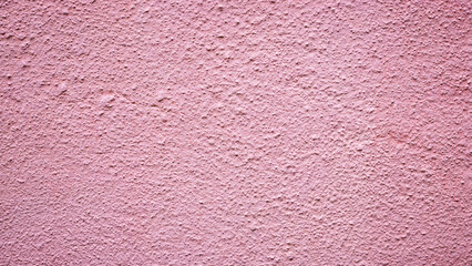 Fototapeta premium Pink wall with a rough texture seen during daylight in an outdoor setting