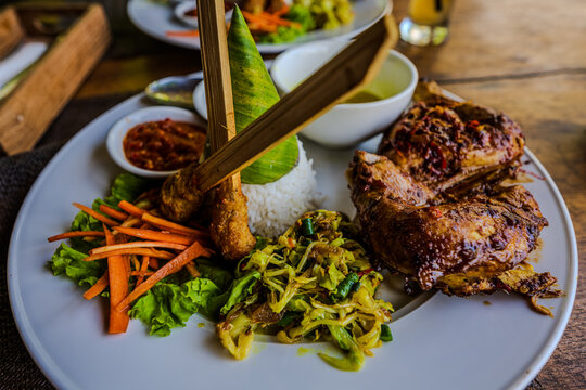Traditional Balinese meal with roasted chicken and satay lilit
