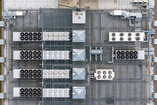Aerial view of the industrial rooftop of secure data center facility featuring HVAC systems, ventilation fans, and complex piping in Warszawa, Wojewodztwo mazowieckie, Poland.